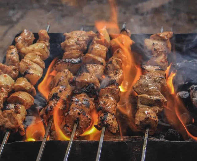 Meat skewers grilling over open flame