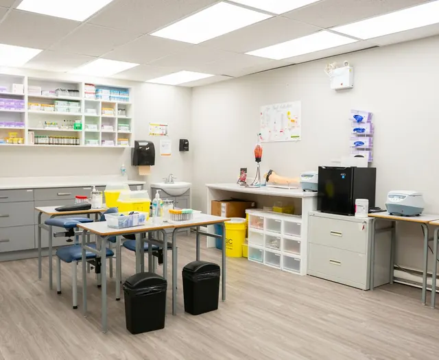 A bright medical training room with supplies and stools