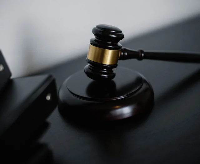 A wooden gavel on a dark desk